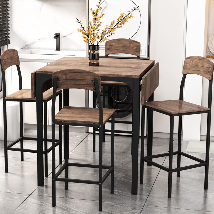 a kitchen table with four chairs and a vase filled with flowers on the counter top