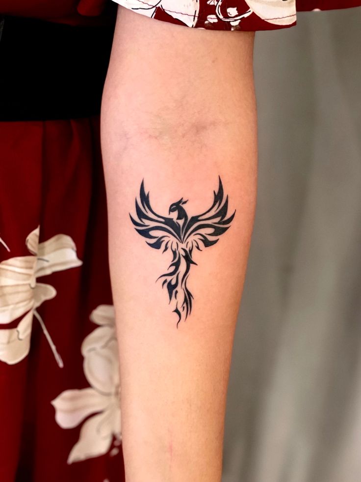 a woman's arm with a tattoo on it that has a bird on it