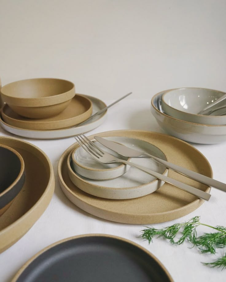 a table topped with plates and bowls filled with utensils next to each other