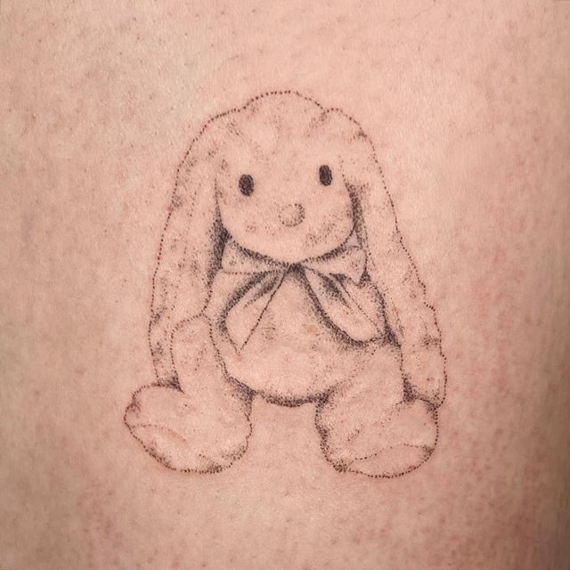 a drawing of a stuffed animal on the back of a person's stomach,