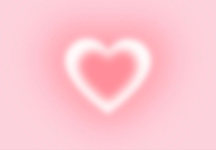 a blurry image of a heart on a pink background