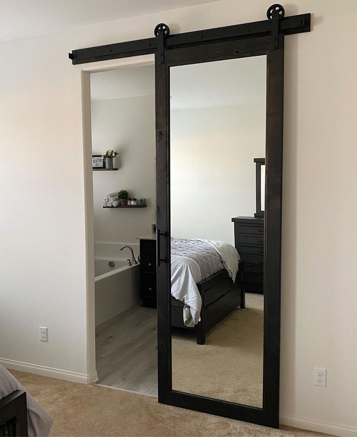 a bedroom with a large mirror on the wall