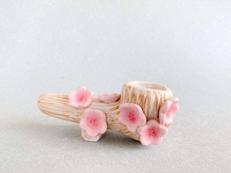 a small figurine with pink flowers on it