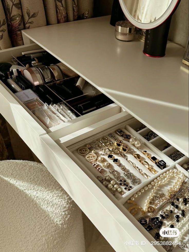 the drawers are filled with jewelry and bracelets in this dressing table area, which is also used as a vanity