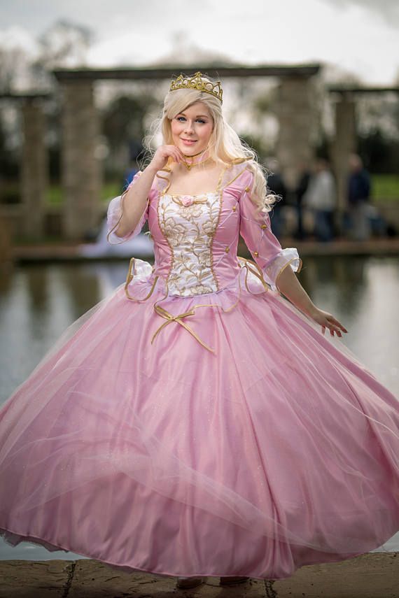 a woman in a pink dress is posing for the camera while wearing a tiara