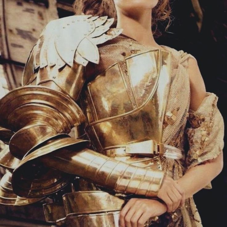 a woman dressed in armor poses for a magazine cover