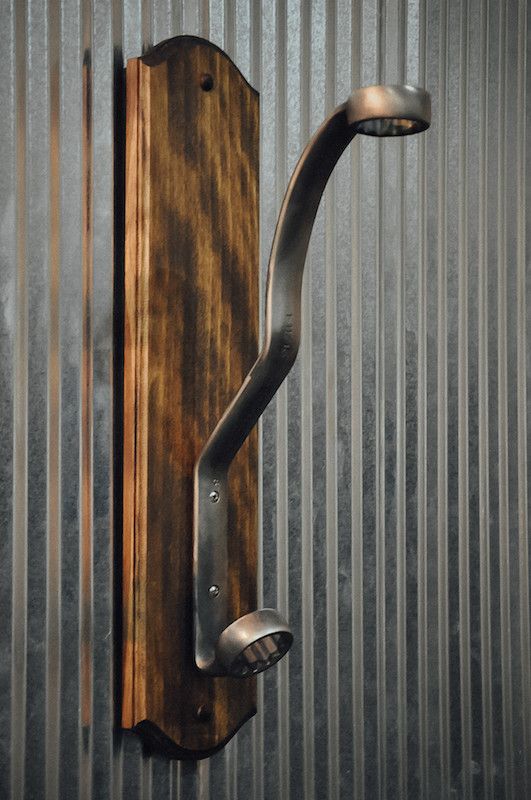 a metal and wood door handle on the side of a corrugated - iron wall unit