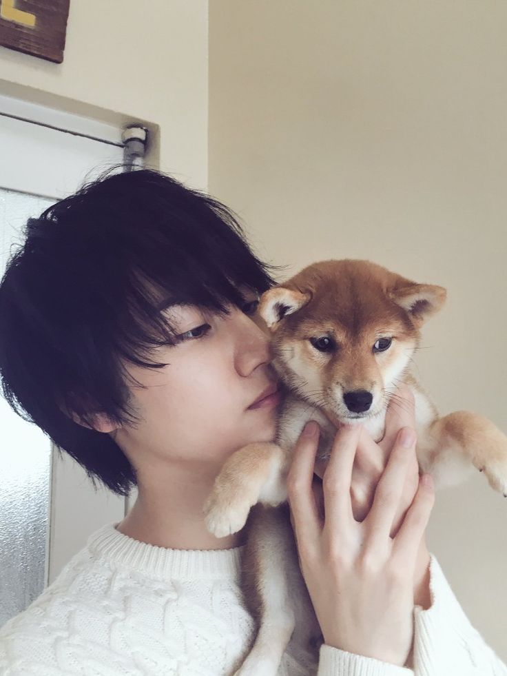 a woman holding a small dog up to her face