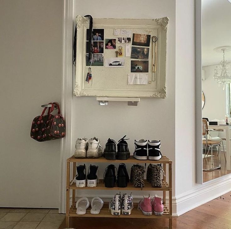 there is a shoe rack with shoes on it in front of a mirror and door