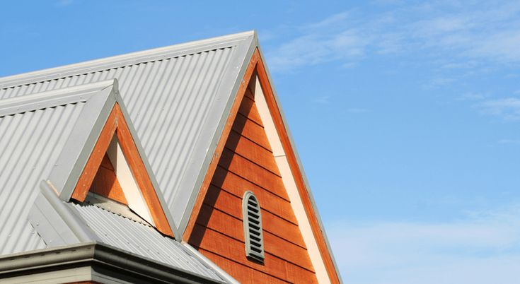 an orange and white building with a clock on it's face in front of a blue sky