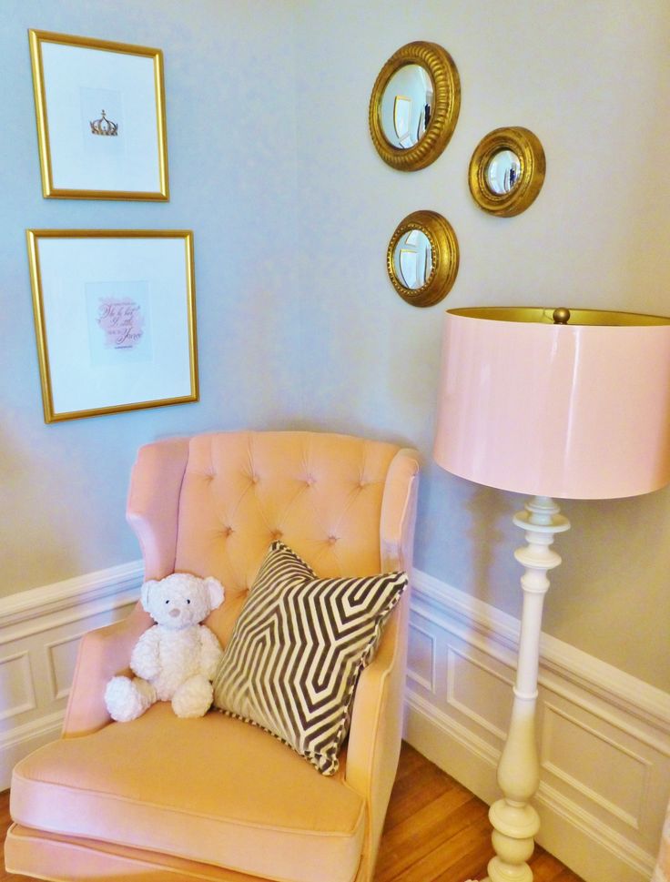 a chair with a teddy bear sitting on it next to a lamp and some pictures