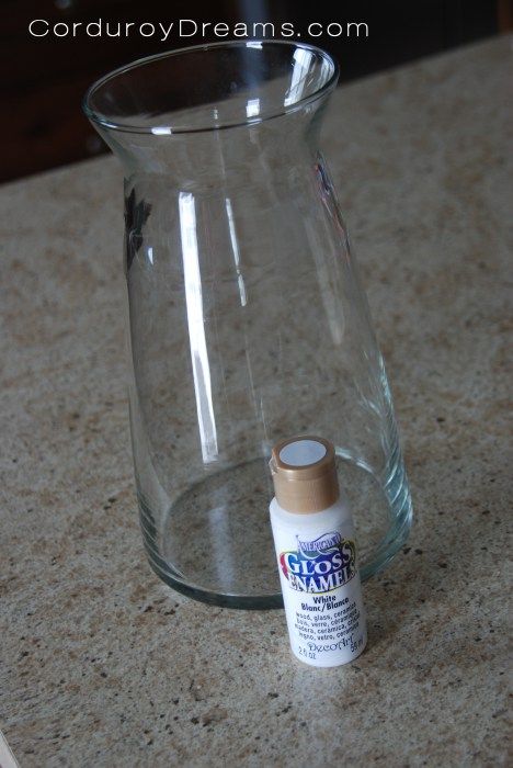 a glass vase sitting on top of a counter next to a small tube of glue