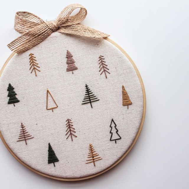 an embroidered christmas ornament with trees on it