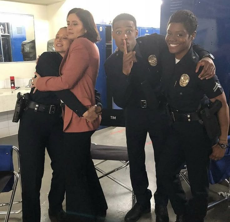 three police officers standing next to each other and posing for the camera with their arms around one another