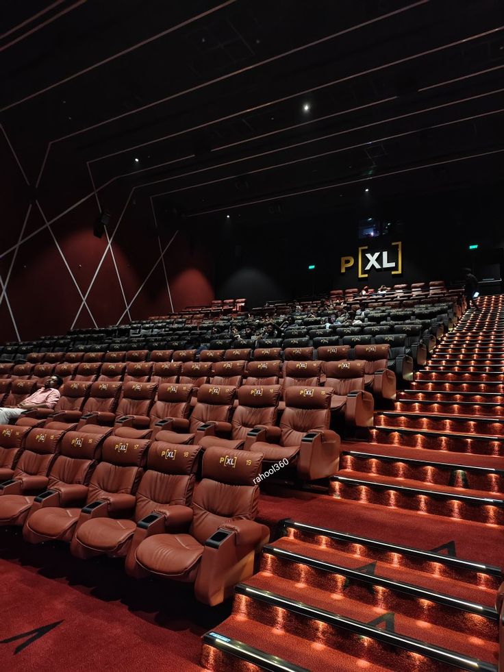 an empty auditorium with rows of brown seats