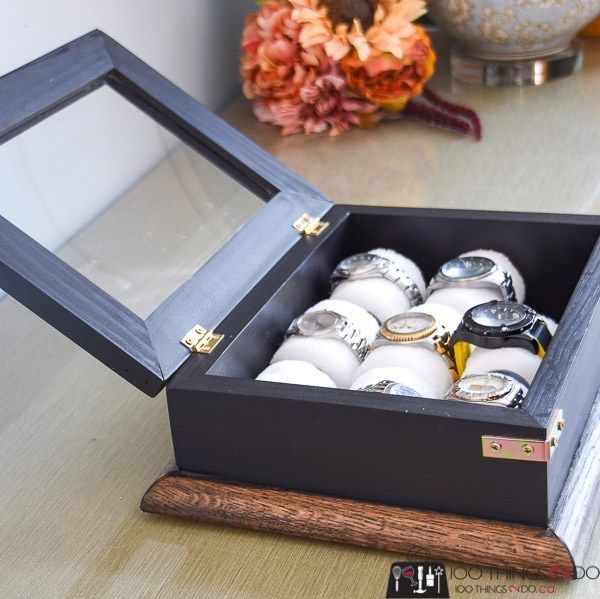 a wooden box filled with lots of white and black balls on top of a table