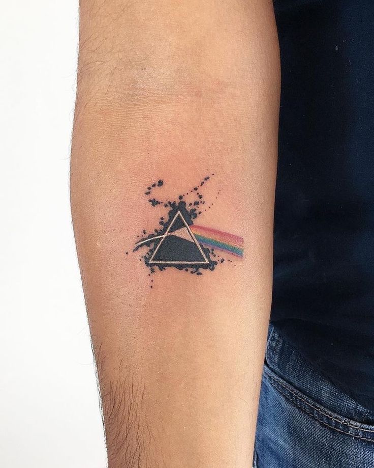 a man's arm with a tattoo on it that has the dark side of the moon