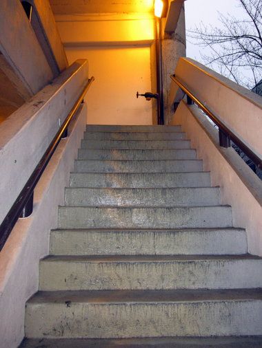 stairs leading up to the top of a building with light coming in from behind them