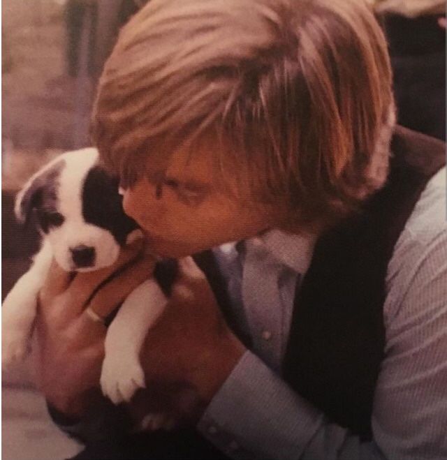 a young man holding a puppy in his lap