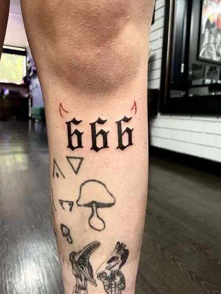 a person with a tattoo on their leg that has letters and mushrooms all over it