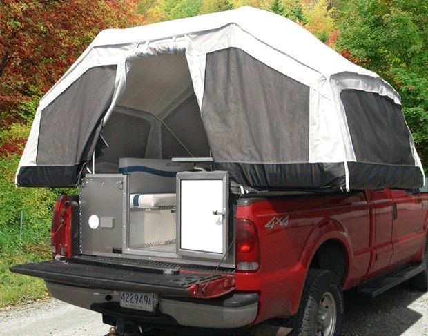 the back end of a red truck with a tent on it