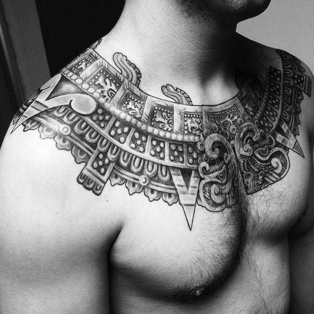 a man's chest is adorned with intricate designs and geometrical shapes in black and white