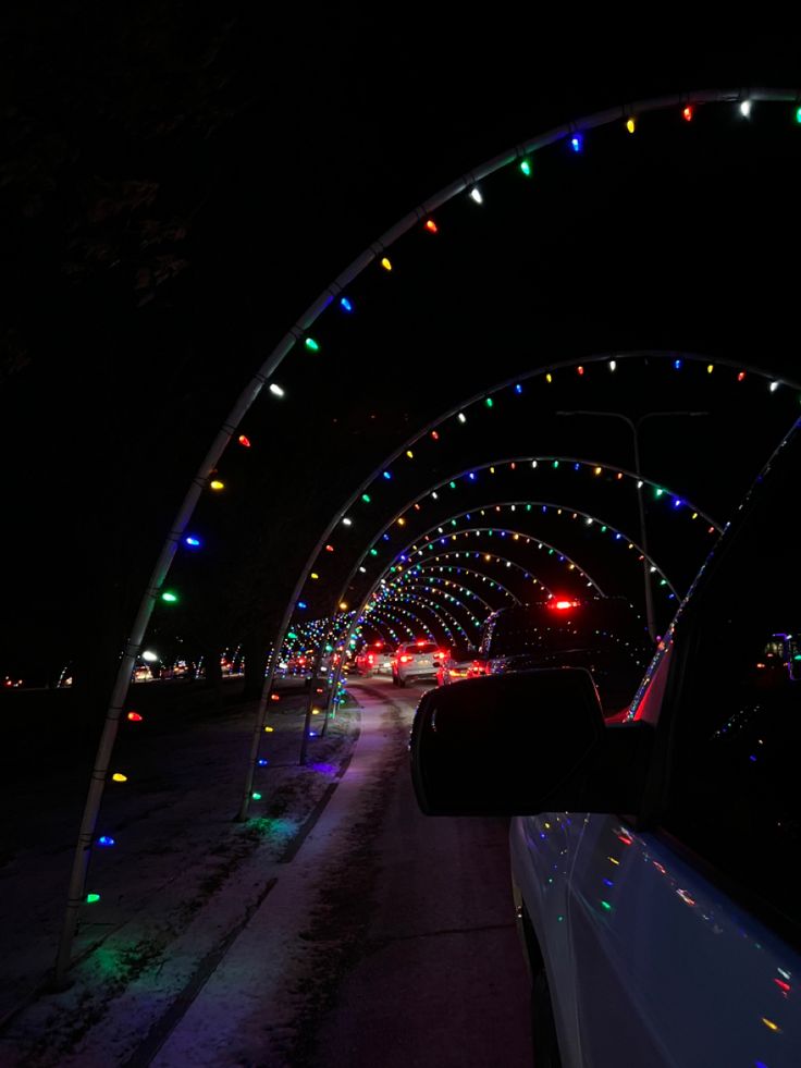 a car driving down a road covered in christmas lights