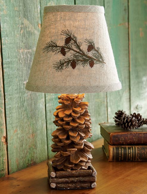 a pine cone lamp sitting on top of a wooden table