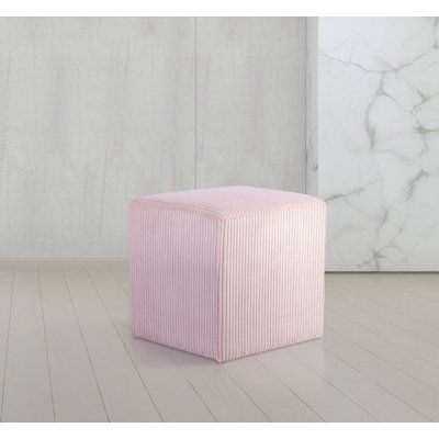 a pink stool sitting on top of a hard wood floor next to a white wall