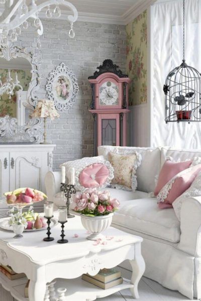 a white couch sitting next to a table with flowers on it in a living room