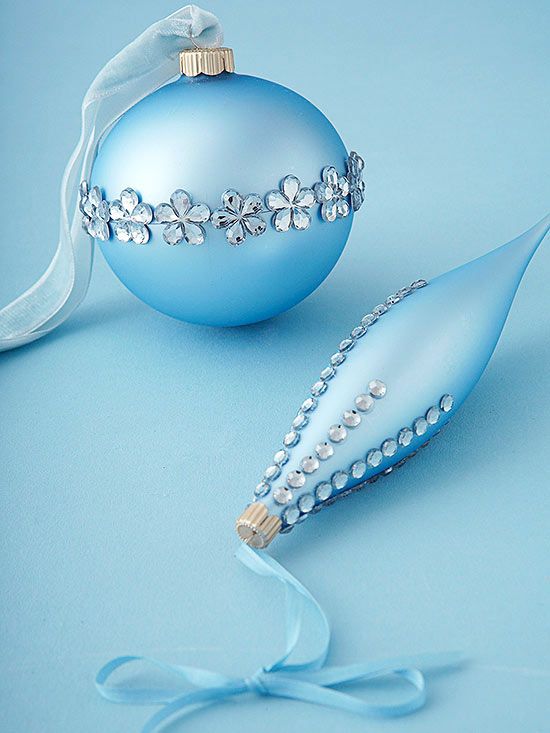 a blue ornament and ribbon on a light blue background