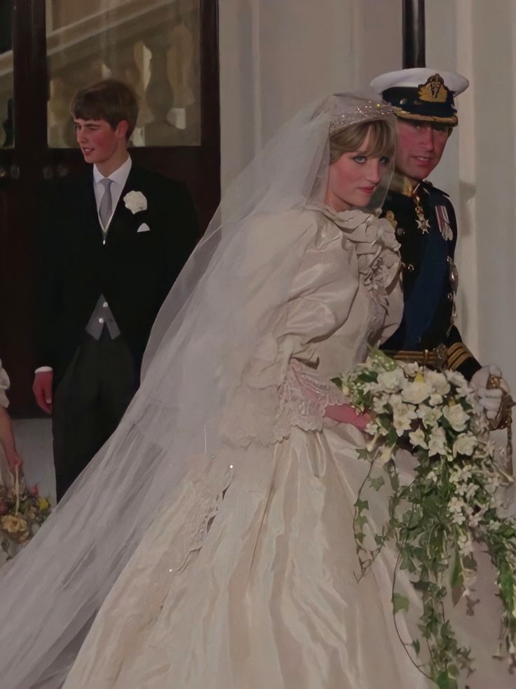 the bride and groom are walking down the aisle in their wedding gowns, which is adorned with flowers