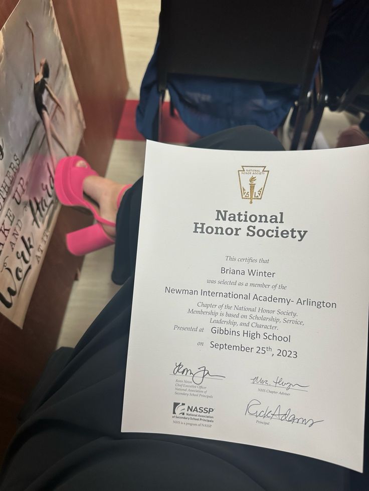 a person holding up a paper with the national honor society written on it in front of them