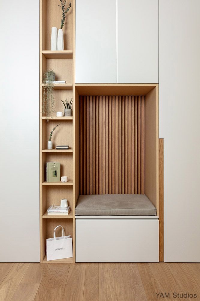 an empty shelf in the corner of a room with white cupboards and shelves on each side