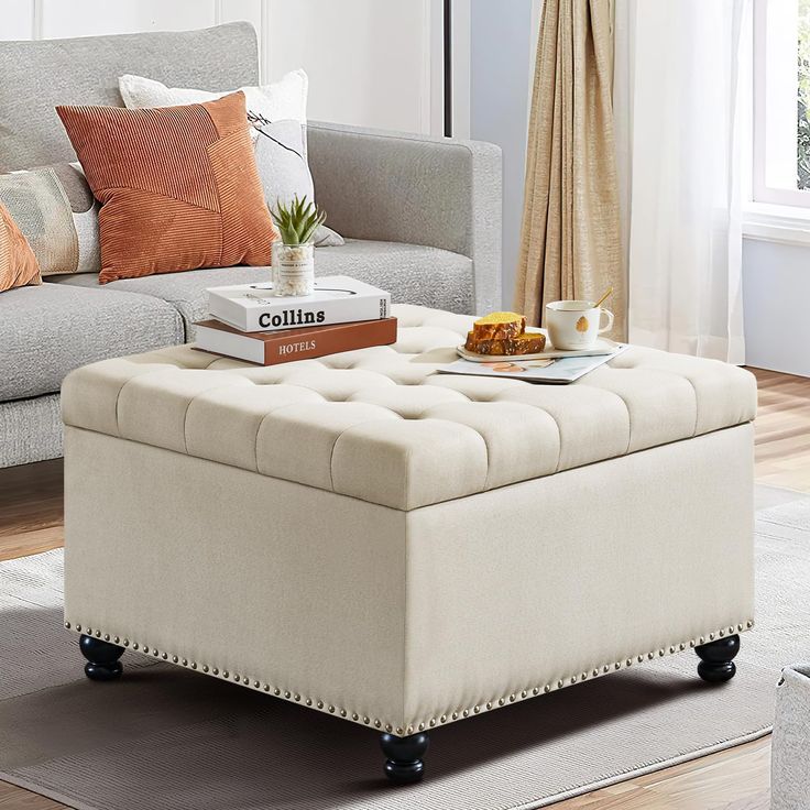 a living room scene with focus on the ottoman and coffee table in the foreground