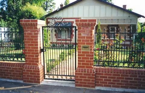 an iron gate is in front of a brick house