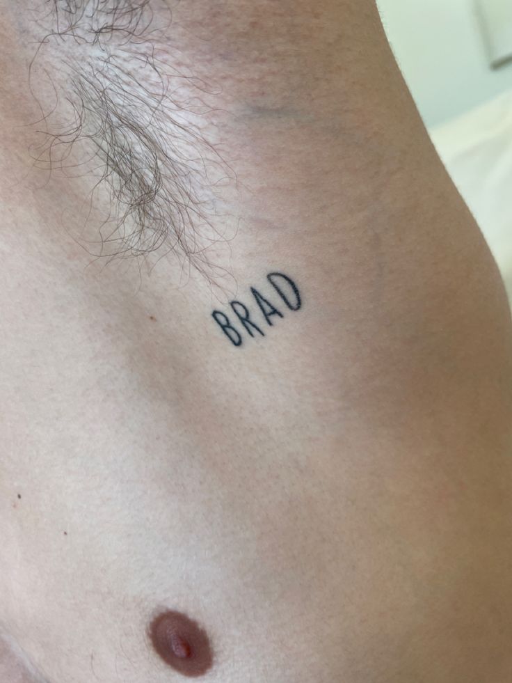 a man's chest with the word bad tattooed on it