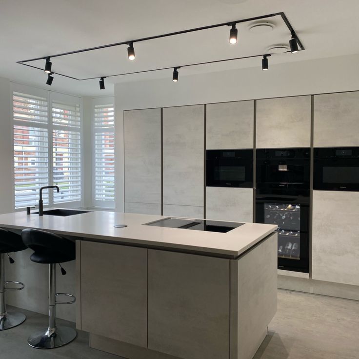 a modern kitchen with an island and bar stools