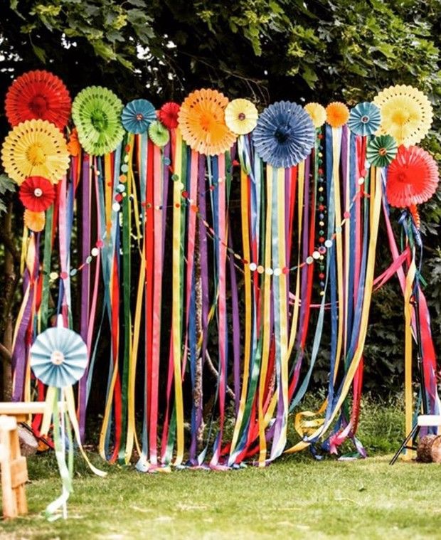 colorful streamers and ribbons are hanging on the wall in front of a picnic table