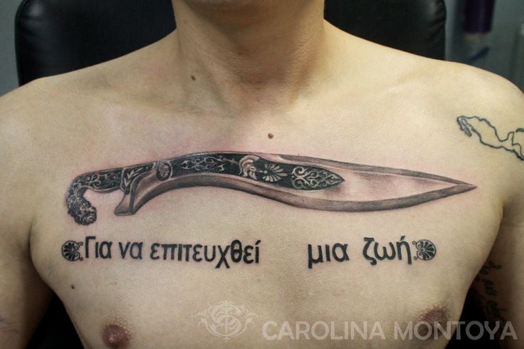 a man with a knife tattoo on his chest