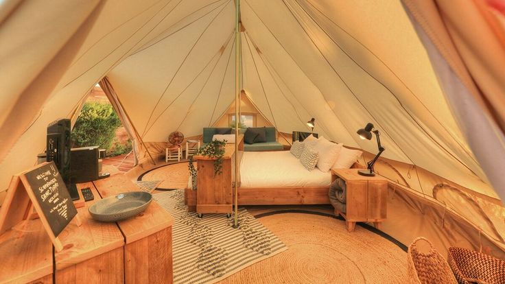 the inside of a tent with a bed and desk