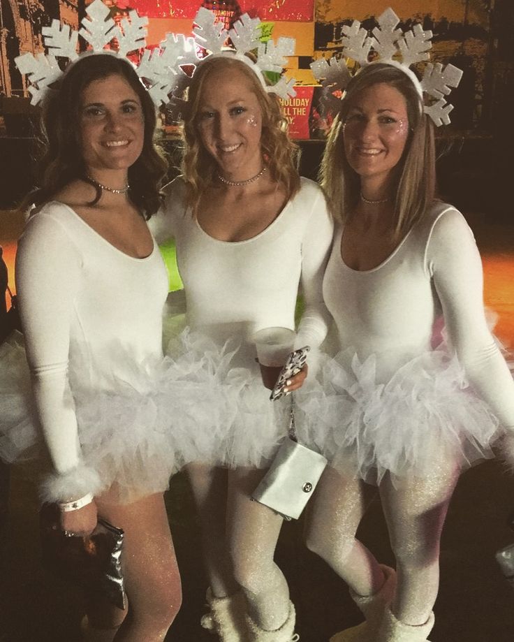 three women dressed in white posing for the camera