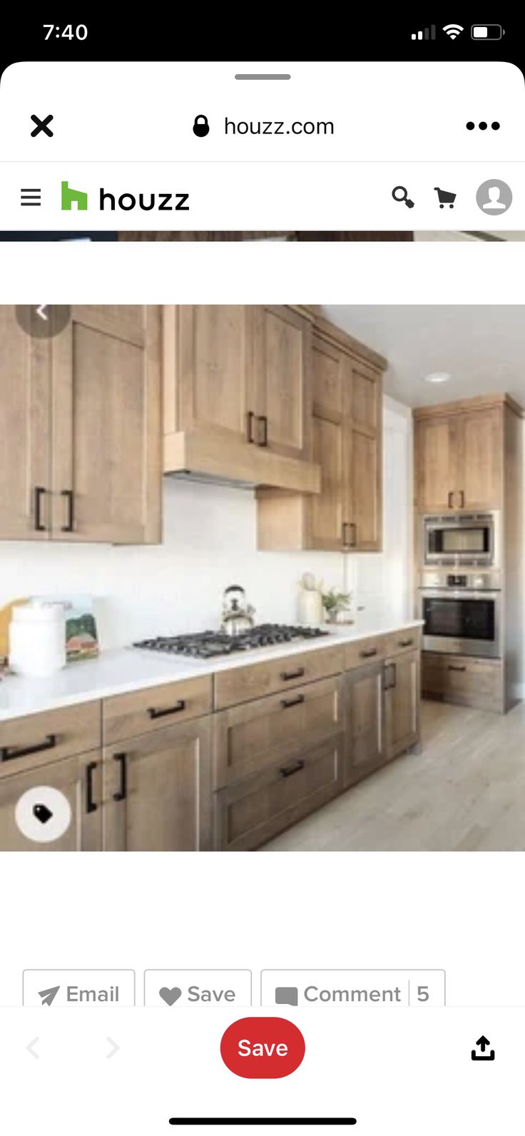 an image of a kitchen with wooden cabinets and white counter tops on the phone screen