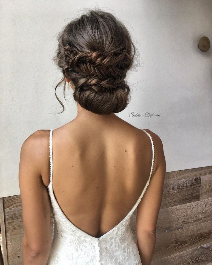 the back of a woman's wedding dress, with her hair in a low bun