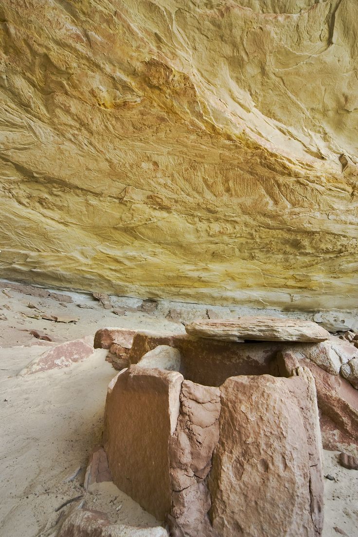 a rock formation in the middle of a desert with a bench on it's side