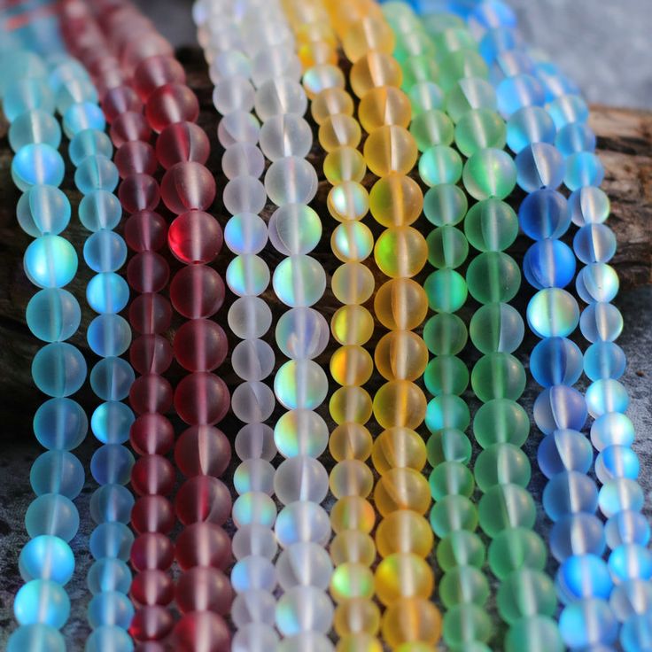 there are many different colored beads on the table