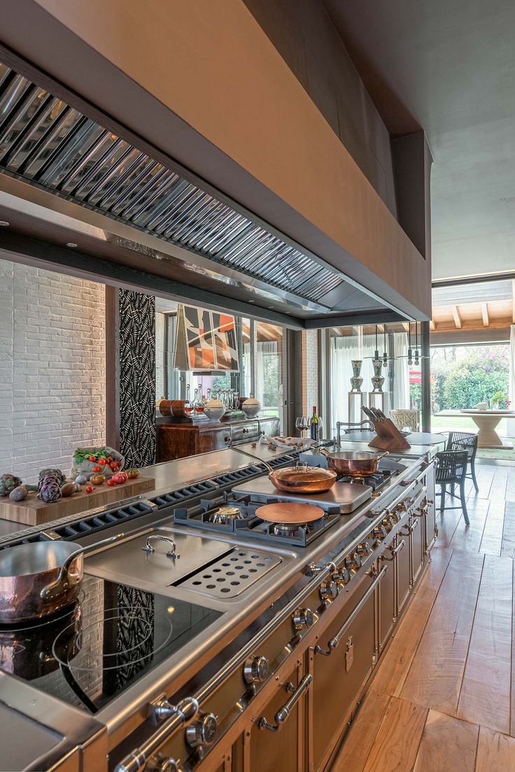 a large kitchen with lots of counter space and stainless steel stove top ovens on both sides