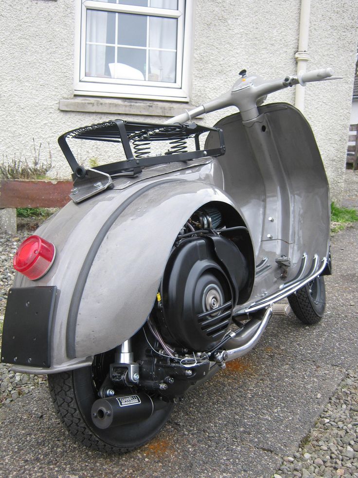 an old motorcycle parked in front of a building