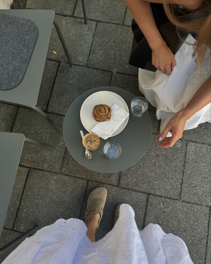 two people sitting at a table with food on it