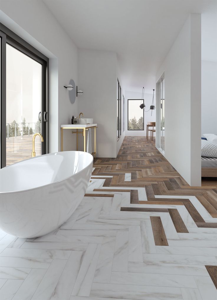 an image of a white bathroom with wood flooring and large tub in the middle